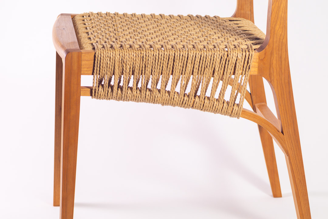 Lupin Chair — rear three-quarter view showing cord seat and curved legs
